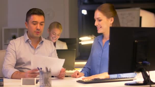 Бизнес-команда с бумагами, работающими поздно в офисе — стоковое видео