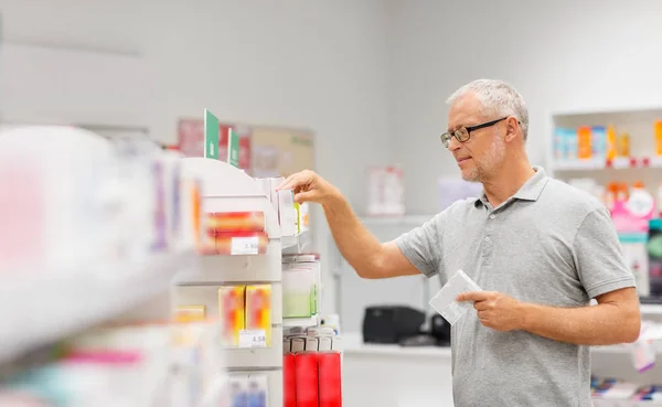 Senior client masculin avec des médicaments à la pharmacie — Photo