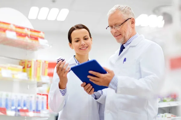 Speziali con tablet pc e farmaco in farmacia — Foto Stock