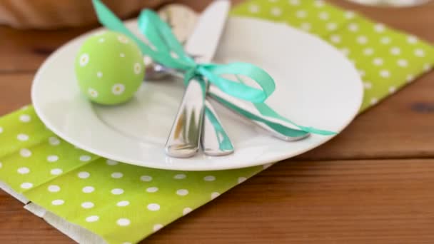 Huevos de Pascua en cesta y flores en mesa servida — Vídeos de Stock