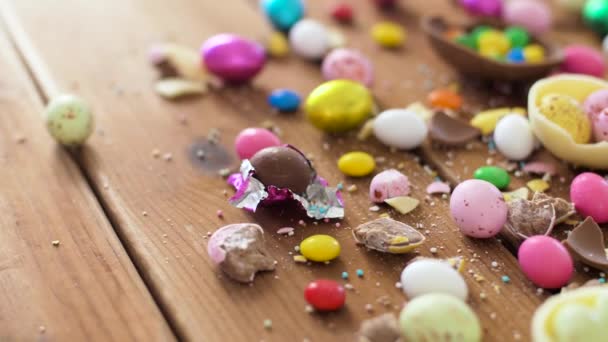 Шоколадні великодні яйця і крапля цукерок на столі — стокове відео