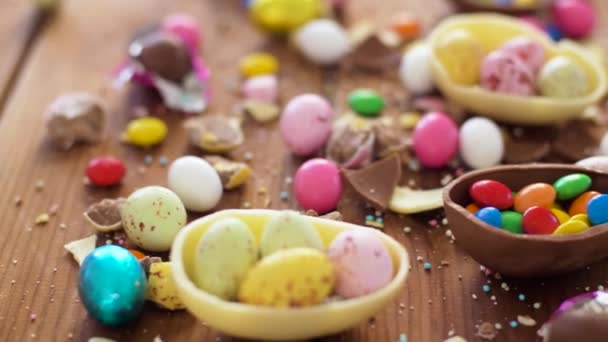 Chocolate easter eggs and drop candies on table — Stock Video