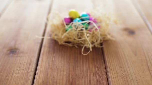 Chocolate easter eggs in straw nest on table — Stock Video
