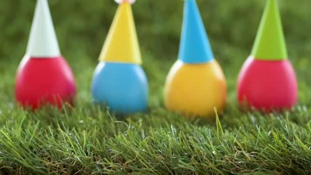 Easter eggs in party caps on artificial grass — Stock Video