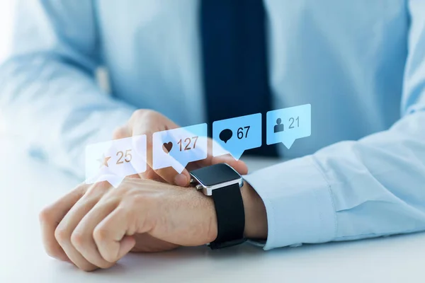 Mãos com relógio inteligente e ícones de mídia social — Fotografia de Stock
