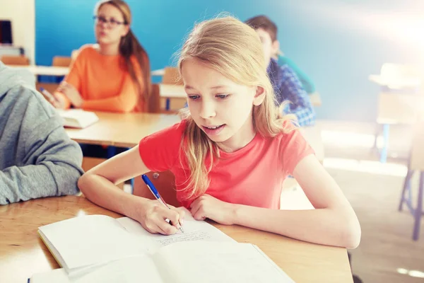 Student meisje met boek schrijven van test van de school — Stockfoto