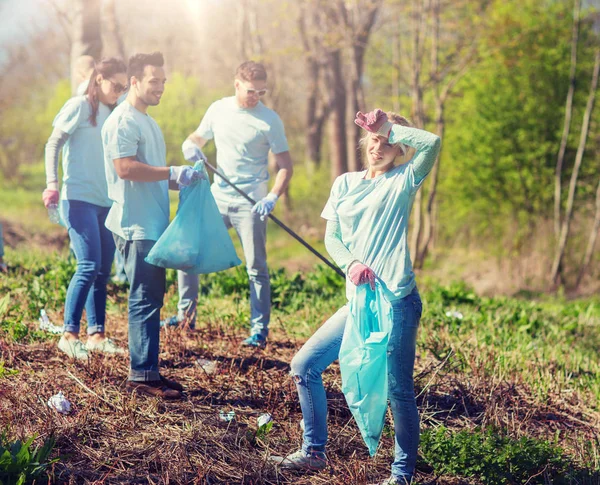 Volunteers with garbage bags cleaning park area — Stock Photo, Image