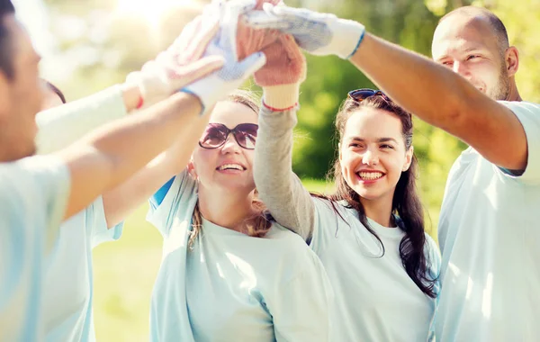 Gruppe von glücklichen Freiwilligen macht High Five im Park — Stockfoto