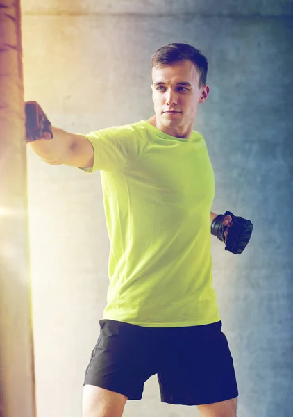 Jeune homme en gants boxe avec sac de boxe — Photo