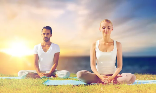 Yoga yapmak ve açık havada meditasyon mutlu çift — Stok fotoğraf