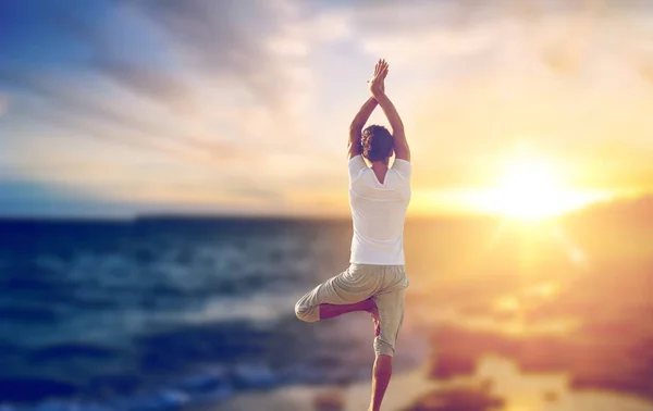 Homem feliz fazendo ioga árvore pose sobre o mar — Fotografia de Stock