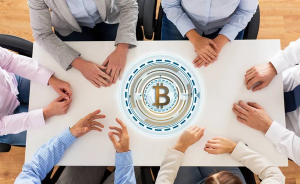 Equipo de negocios en la mesa con el icono de bitcoin — Foto de Stock