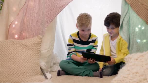 Маленькие мальчики с планшетным ПК в детской палатке дома — стоковое видео