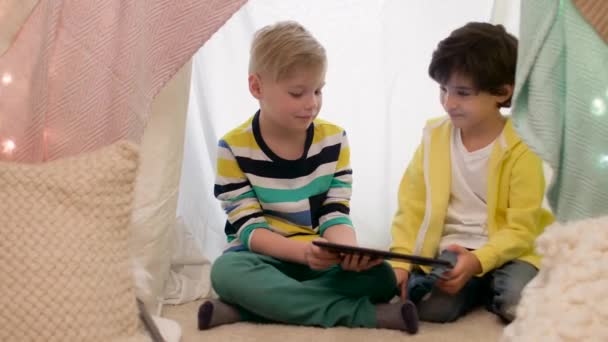 Маленькие мальчики с планшетным ПК в детской палатке дома — стоковое видео