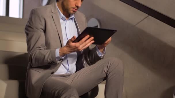 Бизнесмен с планшетным ПК на офисной лестнице — стоковое видео