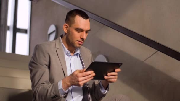 Businessman with tablet pc at office stairs — Stock Video