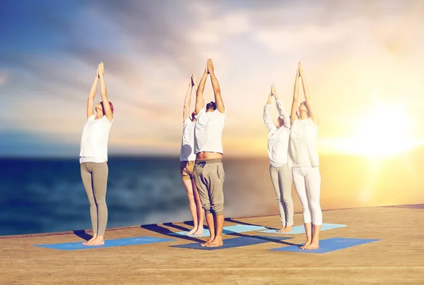 Grupo de personas haciendo yoga al aire libre — Foto de Stock