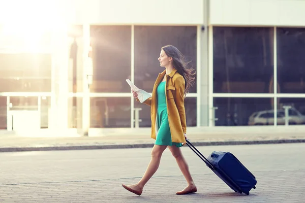 Glückliche junge Frau mit Reisetasche und Stadtplan in der Stadt — Stockfoto