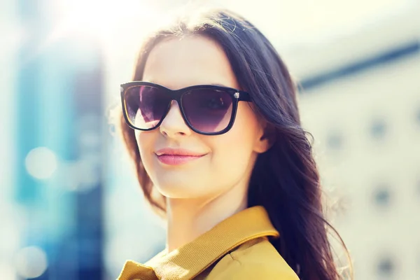 Sorrindo jovem mulher com óculos de sol na cidade — Fotografia de Stock