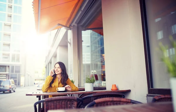 Happy woman calling on smartphone at city cafe — Stock Photo, Image