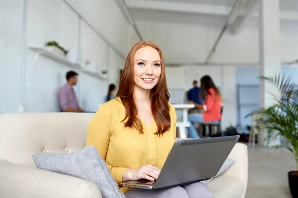 Femme heureuse avec ordinateur portable travaillant au bureau — Photo
