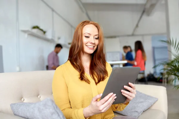 Roodharige vrouw met tablet-pc werken op kantoor — Stockfoto