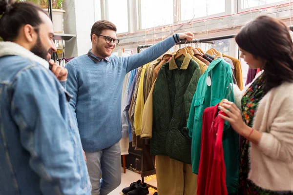 Freunde suchen Kleidung im Vintage-Bekleidungsgeschäft aus — Stockfoto