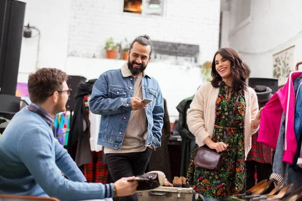 Freunde suchen Kleidung im Vintage-Bekleidungsgeschäft aus — Stockfoto