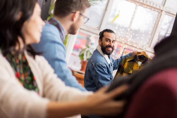 Freunde suchen Kleidung im Vintage-Bekleidungsgeschäft aus — Stockfoto