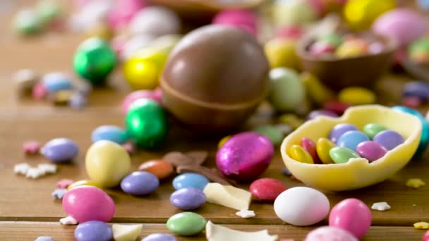 Uova di Pasqua al cioccolato e caramelle goccia sul tavolo — Video Stock