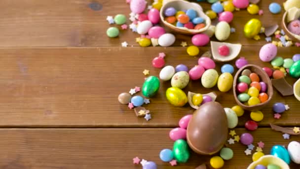 Chocolate easter eggs and drop candies on table — Stock Video