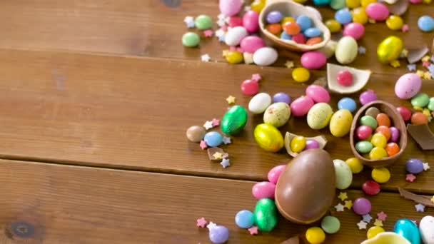 Chocolate easter eggs and drop candies on table — Stock Video