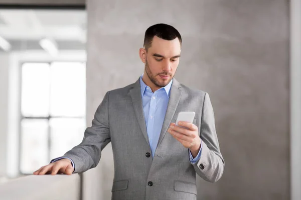 Homem de negócios com smarphone no escritório — Fotografia de Stock