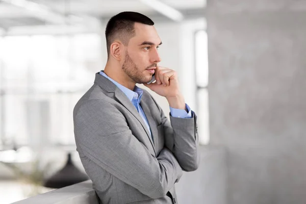 Uomo d'affari che chiama su smartphone in ufficio — Foto Stock
