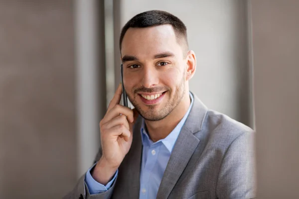 Businessman calling on smartphone at office — Stock Photo, Image