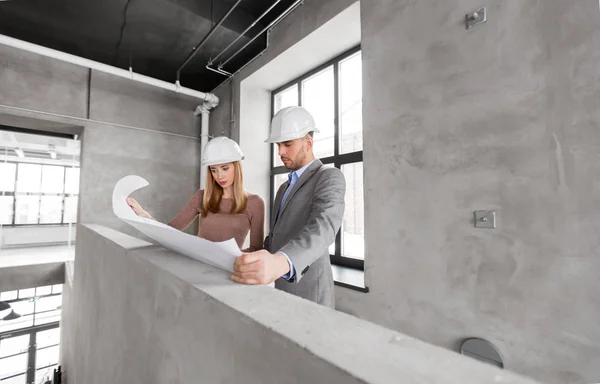 Architects with blueprint and helmets at office — Stock Photo, Image