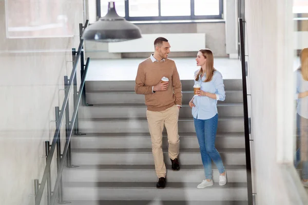 Man and woman with coffee at office stairs — Stock Photo, Image