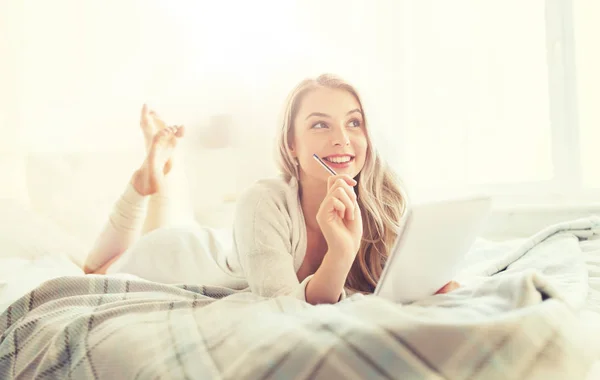 Felice giovane donna con taccuino a letto a casa — Foto Stock