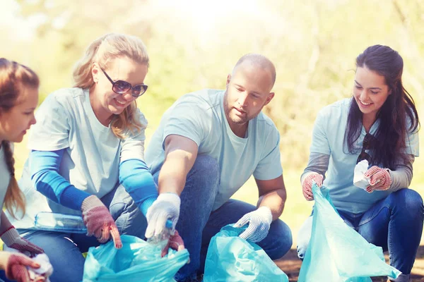 Voluntarios con bolsas de basura limpieza área del parque — Foto de Stock