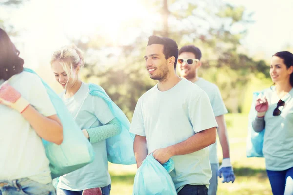Gruppo di volontari con sacchi della spazzatura nel parco — Foto Stock