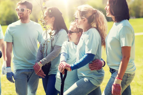 Grupp av frivilliga med träd och spade i park — Stockfoto