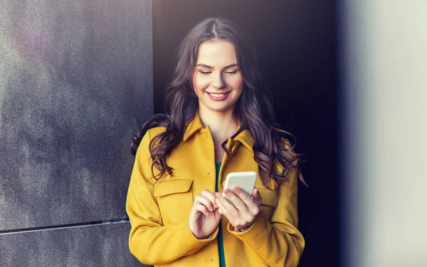 Sonriente joven mujer o niña mensajes de texto en el teléfono inteligente —  Fotos de Stock