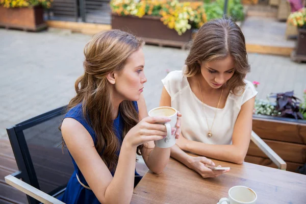 Mulheres jovens com smartphone e café no café — Fotografia de Stock