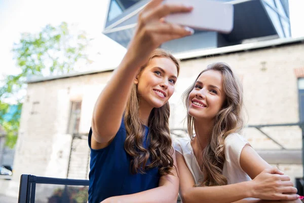 Unga kvinnor som tar selfie av smartphone på café — Stockfoto