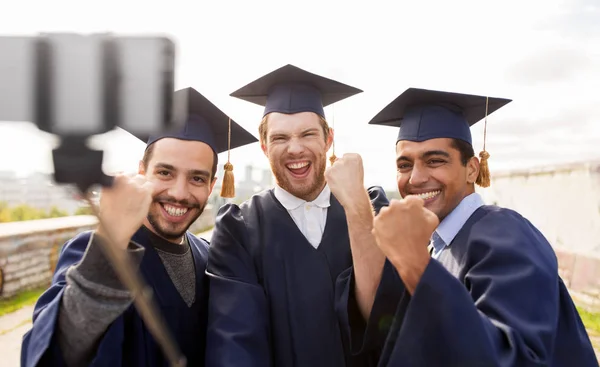Felici studenti di sesso maschile o laureati prendendo selfie — Foto Stock