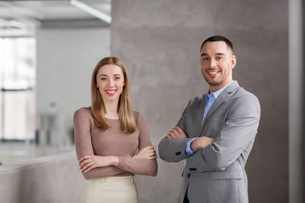 Sonriente mujer de negocios y hombre de negocios en la oficina — Foto de Stock