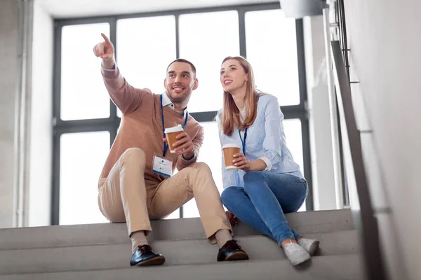 Man en vrouw met conferentiebadges koffie drinken — Stockfoto