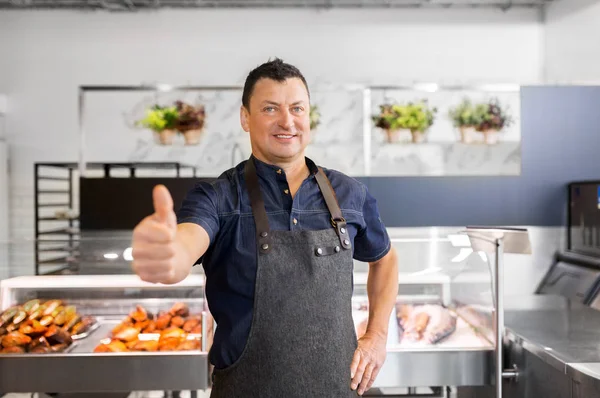 Fisk och skaldjur säljaren vid fiskaffären visar tummen — Stockfoto