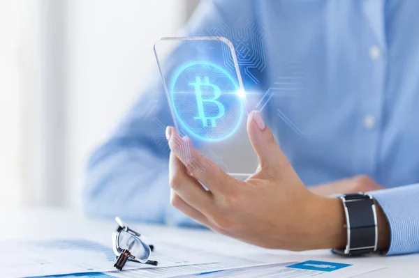 Close up of bitcoin on transparent smartphone — Stock Photo, Image