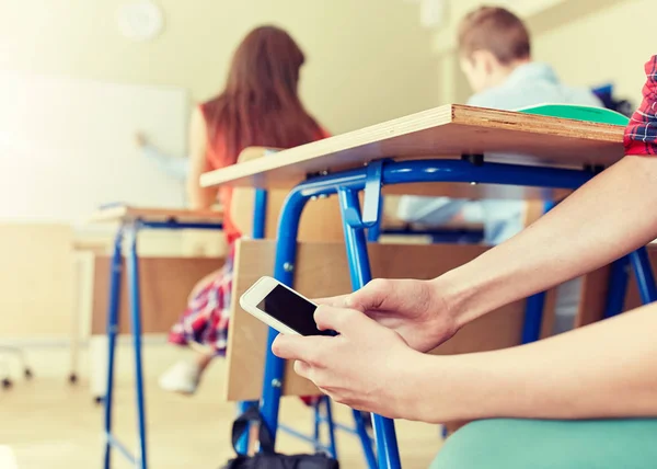 Student jongen met smartphone SMS op school — Stockfoto